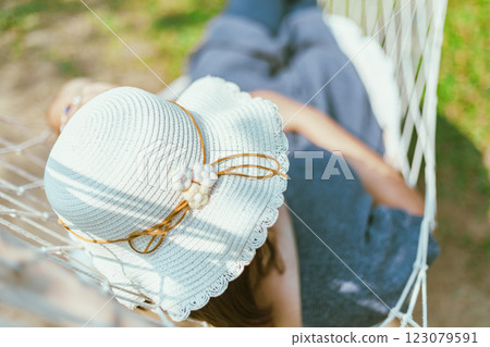 Women covering face with hat sleeping on hammock 123079591