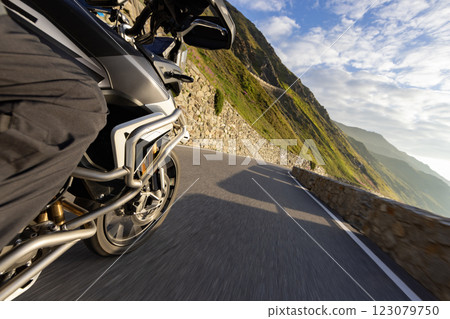 Motorbiker riding in Italian Alps during sunrise, dramatic sky. Travel and freedom, outdoor activities Motorbiker riding in Italian Alps during sunrise, dramatic sky. Travel and freedom, outdoor activities 123079750