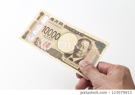 Hand holding a 10,000 yen bill Hand holding a 10,000 yen bill 123079913