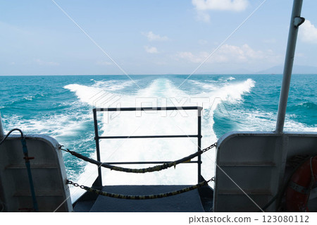 A vessel glides through serene blue waters, leaving soft white waves in its wake. The backdrop features a bright sky dotted with clouds, evoking a sense of peace and adventure. A vessel glides through serene blue waters, leaving soft white waves in its wake. The backdrop features a bright sky dotted with clouds, evoking a sense of peace and adventure. 123080112