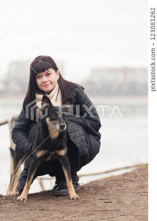 Portrait of a woman holding her dog on a walk Portrait of a woman holding her dog on a walk 123081262