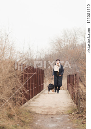 Woman and her dogs on an old rusty bridge on a cloudy day 123081320