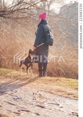 Woman in hat walking with dog, photo from the back 123081550