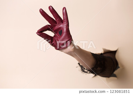 Female hand in red leather glove showing gesture Ok Female hand in red leather glove showing gesture Ok 123081851