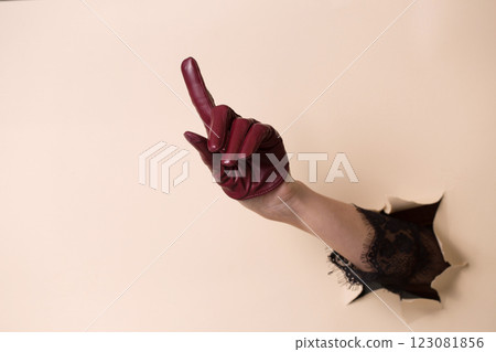 A woman's hand in a leather glove shows a gesture forefinger 123081856