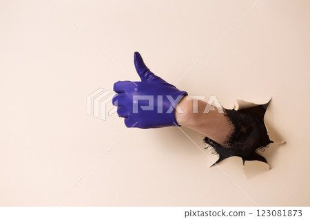 A woman's hand in a leather blue glove shows a gesture good 123081873