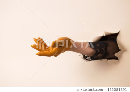 A woman's hand in a leather yellow glove shows a gesture of request A woman's hand in a leather yellow glove shows a gesture of request 123081891
