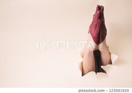 Two hands in burgundy leather gloves folded in a prayer 123081920