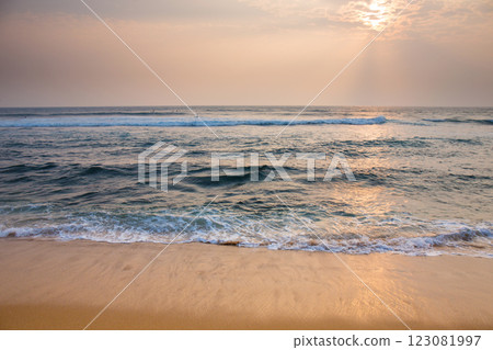 The sun is setting, casting a warm glow over the ocean 123081997