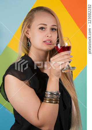 Cheerful blonde woman holding two glasses of red wine and smiling 123082282
