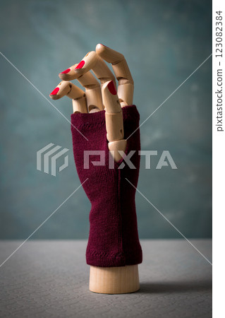 A mannequin hand with red nails and a maroon glove A mannequin hand with red nails and a maroon glove 123082384
