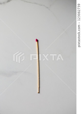 One long fireplace match with pink head on white marble background One long fireplace match with pink head on white marble background 123082739