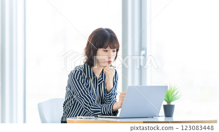 Smiling woman/businesswoman doing desk work Smiling woman/businesswoman doing desk work 123083448