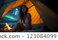 Beautiful woman camping under the northern lights in Iceland 123084099