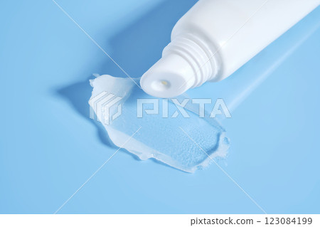 White lip balm in a tube on a blue background. The texture. White lip balm in a tube on a blue background. The texture. 123084199