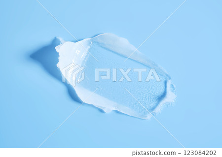 White lip balm in a tube on a blue background. The texture. White lip balm in a tube on a blue background. The texture. 123084202
