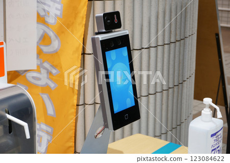 Facial recognition, body temperature measuring devices and hand sanitizer at facility entrances 123084622