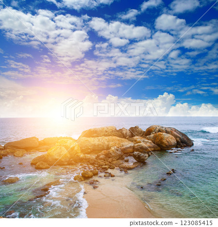 Panoramic beach landscape. Sunrise on rocky shore of tropical sea. 123085415
