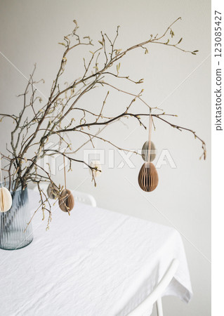 Easter paper eggs hanging on branches. Easter tablescape decor. 123085427