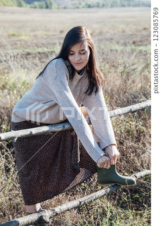 Beautiful brunette woman in sweater in rural area Beautiful brunette woman in sweater in rural area 123085769