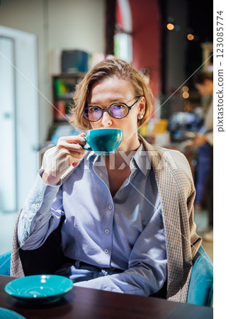 woman drinking coffee tea in book restaurant woman drinking coffee tea in book restaurant 123085774