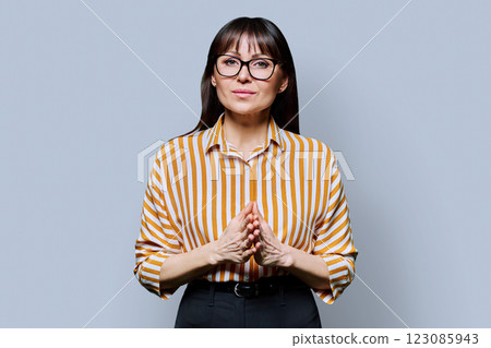 Portrait of smiling business mature woman on grey background Portrait of smiling business mature woman on grey background 123085943