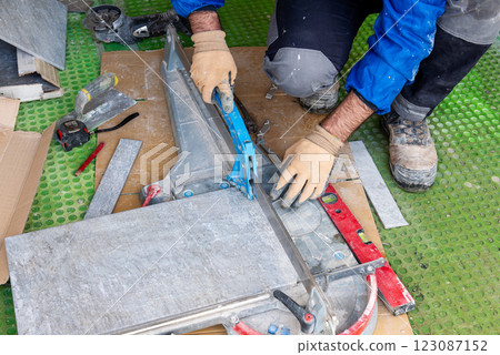 Tiler at work installing new floor with tiles. Construction. Tiler at work installing new floor with tiles. Construction. 123087152