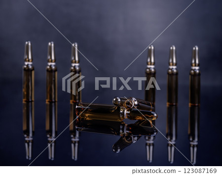 Ampoules with medicine on glossy black background 123087169