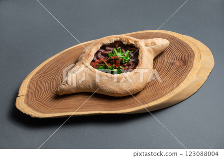 Delicious traditional dish khachapuri served on a wooden board showcasing culinary art and fresh ingredients 123088004