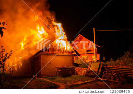 Wooden house or barn burning on fire at night. 123089466
