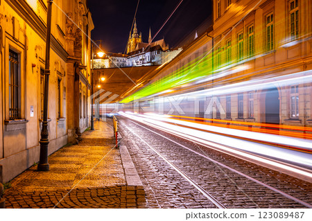 Letenska Street glows at night as light trails from trams create a dynamic view. Prague Castle looms in the background, showcasing the beauty of Lesser Town. 123089487