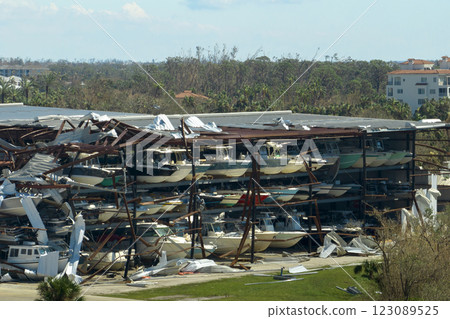 Warehouse with motorboats and yachts destroyed by hurricane winds in Florida coastal area. Natural disaster and its consequences 123089525