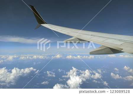 View through airplane window of commercial jet plane wing flying high in the sky. Air travelling concept View through airplane window of commercial jet plane wing flying high in the sky. Air travelling concept 123089528
