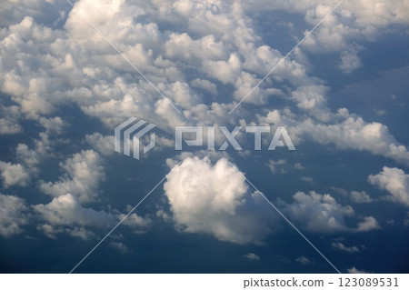 View from plane window of white rain clouds forming on blue sky. Air travel concept View from plane window of white rain clouds forming on blue sky. Air travel concept 123089531