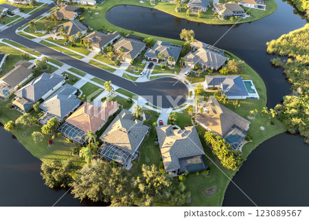 Upscale suburban homes at sunset with large backyards and green grassy lawns. Private residential houses in rural suburban sprawl area in Sarasota, Florida 123089567
