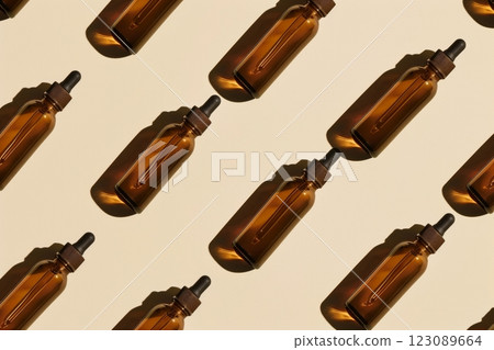 A collection of brown glass dropper bottles is organized meticulously in a symmetrical layout on a neutral background A collection of brown glass dropper bottles is organized meticulously in a symmetrical layout on a neutral background 123089664