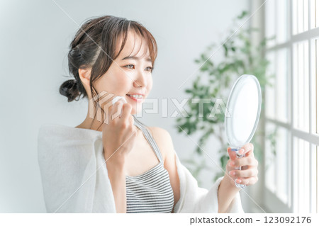 亞洲女性用棉花在皮膚上塗抹乳液 123092176