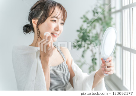 亞洲女性用棉花在皮膚上塗抹乳液 123092177