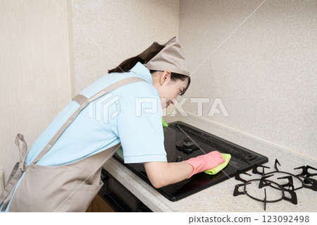 House cleaning woman cleaning the gas stove House cleaning woman cleaning the gas stove 123092498