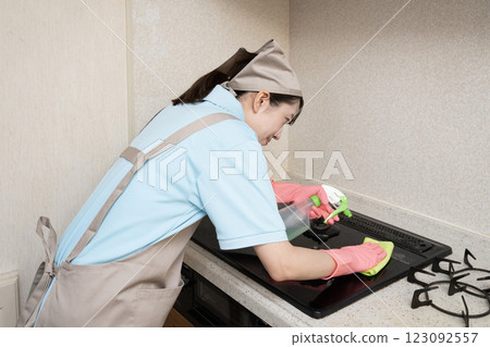 House cleaning woman cleaning the gas stove House cleaning woman cleaning the gas stove 123092557
