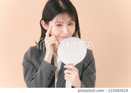 A woman in a suit looking in the mirror 123092629