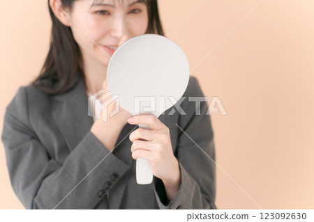 A woman in a suit looking in the mirror A woman in a suit looking in the mirror 123092630