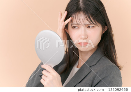 A woman in a suit looking in the mirror A woman in a suit looking in the mirror 123092666