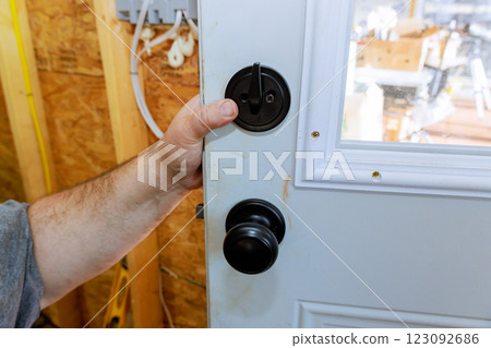 Handyman is installs door handle enter filled with screwdriver tools 123092686