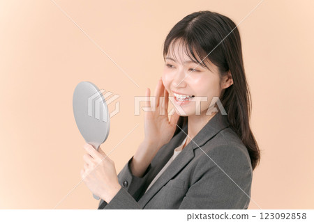 一個穿著西裝的女人照鏡子 一個穿著西裝的女人照鏡子 123092858