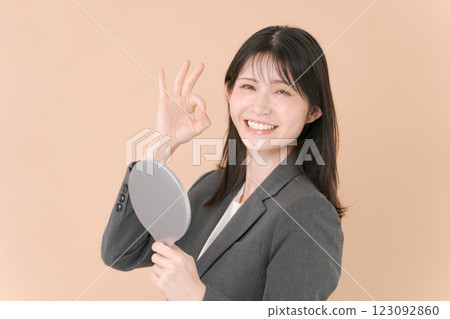 A woman in a suit looking in the mirror 123092860