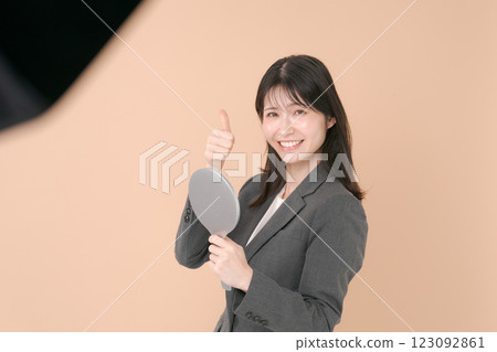 A woman in a suit looking in the mirror 123092861