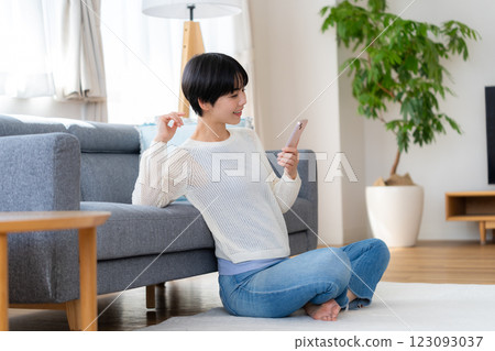 在房間裡操作智能手機的女人 123093037