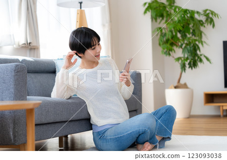 A woman who operates a smartphone in the room A woman who operates a smartphone in the room 123093038