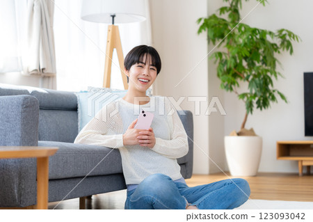 A woman who operates a smartphone in the room A woman who operates a smartphone in the room 123093042